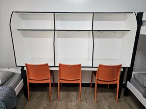 蛍光灯とコンセント付きの勉強机が3つ並んだ3人部屋