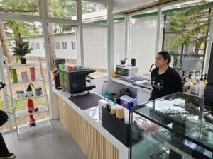 学校のカフェカウンターに立つ女性バリスタ