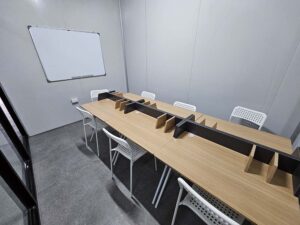 ホワイトボード、長テーブル、椅子があるグループクラスの教室