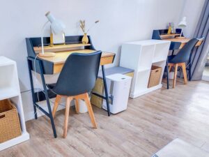 デスクランプ付きの2台の勉強机と小物棚、除湿器が設置された2人部屋