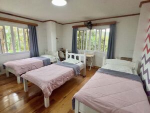 部屋の中央に3台のベッドが並び、窓際に勉強机が置かれた3人部屋
