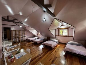 日差しが差し込む屋根裏に4台のベッドが並ぶ女性専用4人部屋