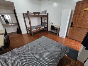 二段ベッドとシングルベッドがあるデラックストリプルルーム