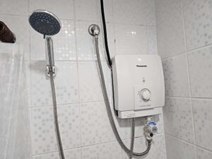 バスルームの壁に取り付けられたシャワーヘッドと温水器