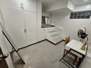 机、扇風機、鏡、クローゼットが備えられた1人部屋の全景