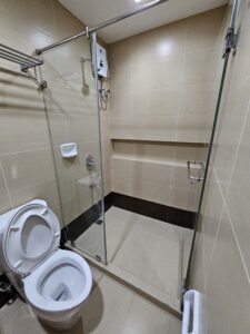 ガラス扉で仕切られたシャワーエリアと、トイレがあるバスルーム