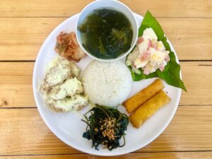 青菜、チキン、春巻き、フルーツサラダ、スープが盛られたプレート