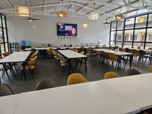 テーブル、椅子、大型モニターが備えられたダイニングエリアの全景