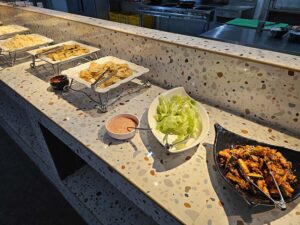 朝食ビュッフェに並んだサラダ、キムチ、天ぷら、ご飯