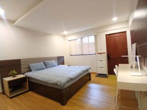 入口ドア、窓、靴棚、キングベッド、勉強机が設置されたベッドルーム