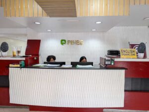 2人のスタッフがいるPINES IELTSのフロントデスク