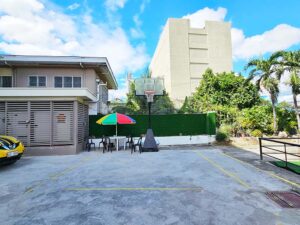 校庭に設置されたバスケットボールゴールとパラソル付きテーブル