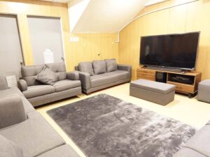 大きなモニターとソファーが並んだマルチメディアルーム