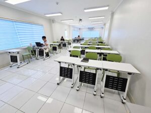 机と椅子が並び、3人の生徒が自習している奥行きのある自習室