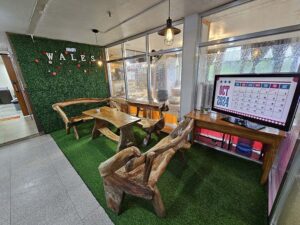 人工芝のカーペットと木製ベンチが置かれたB3階の休憩スペース
