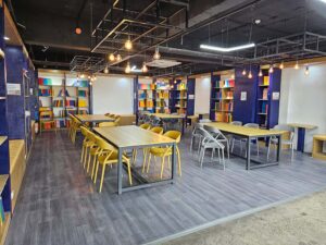 教科書が並ぶ本棚で囲まれた、大きなテーブルが設置されたライブラリ