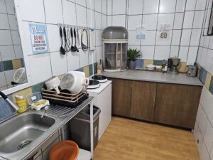 鍋、おたま、IHコンロなどの調理器具が揃った共用キッチン