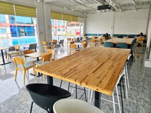 2人の生徒が自習している、異なる高さのテーブルやソファー席が並ぶカフェ