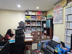 多数の教科書が並ぶ本棚とデスクが置かれた事務スペース