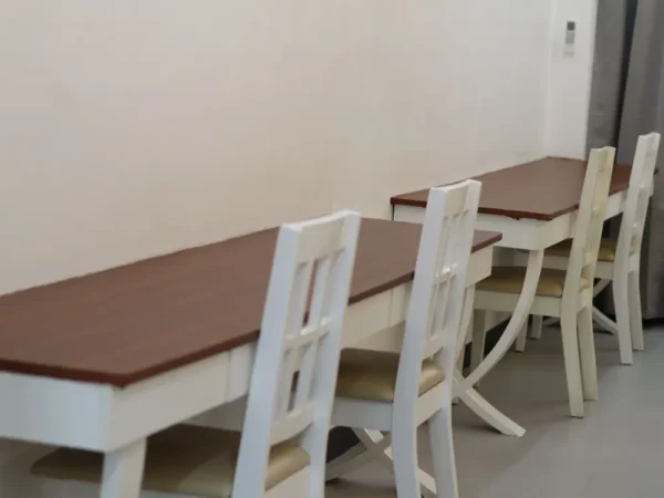 スーペリアクワッドルームの壁際に設置された2台の長机と4脚の椅子