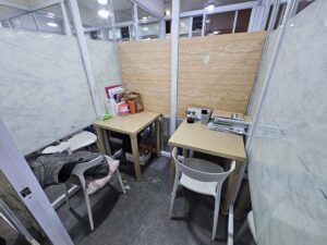 2つのテーブルと椅子が並び、ガラスで仕切られたマンツーマン教室