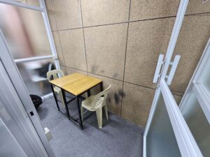すりガラスで囲まれ、机と椅子が対面に配置されたマンツーマン教室