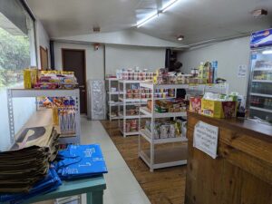 カップラーメンや日用品、スナックが棚に並んだキャンパス内の売店