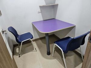 L字に配置された椅子と紫色の机が設置されたマンツーマン教室