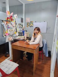 椅子が対面に配置されたマンツーマン教室で笑顔の講師