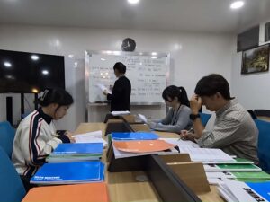 IELTSトライアルクラスで課題に取り組んでいる生徒たちと講師