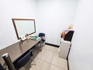 ホワイトボードと長机、本棚が置かれたマンツーマン教室