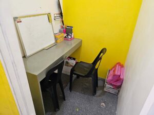 白板の置かれた机に椅子が横並びで配置されたマンツーマン教室