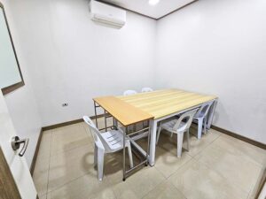 大きなテーブルと5脚の椅子が置かれたスモールグループ教室
