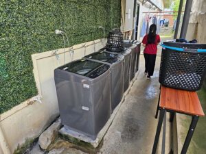 5台の洗濯機が設置されたセルフサービスのランドリーエリア