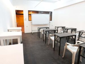 大きなホワイトボードが置かれ、1人掛けの机が並んだグループ教室