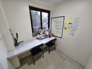 窓際のカウンターと2脚の椅子、ホワイトボードがあるマンツーマン教室