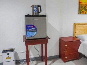 収納棚、電気ケトル、冷蔵庫、除湿器が設置された1人部屋