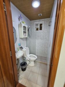 洗面台と小物棚、洗浄便座付きトイレのあるバスルーム