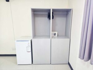 部屋の角に設置されたハンガー付きのワードローブと金庫、冷蔵庫
