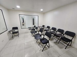 テーブル付き折り畳み椅子が並ぶ大きな窓があるグループクラス教室