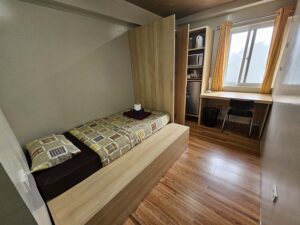 ベッドとクローゼット、机、電子レンジ、冷蔵庫のある1人部屋