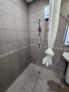 温水器付きシャワーと洗面台のあるバスルーム