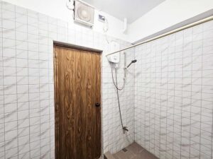 換気扇があり、床の段差とカーテンで仕切られたシャワーエリア