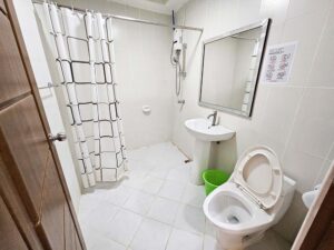 シャワーカーテンと大きな鏡が設置されたバスルーム