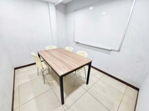 大きなホワイトボードとテーブル、椅子が置かれたグループ教室