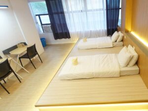 高床に2枚のマットが並び、向かい側に2台の勉強机が置かれた2人部屋