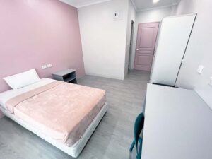 勉強机と椅子、ワードローブ、専用バスルームがあるシングルルーム