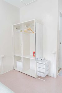 部屋の隅にあるハンガーと金庫が備え付けられたワードローブ