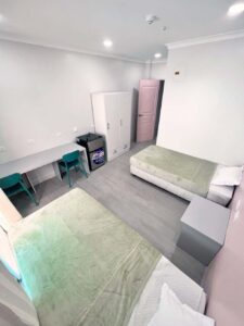 2台のベッドが並び、カウンターテーブルと椅子のある2人部屋