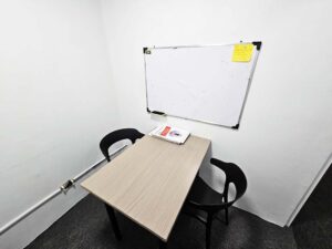 大きめの白板があり椅子が対面に置かれたマンツーマン教室